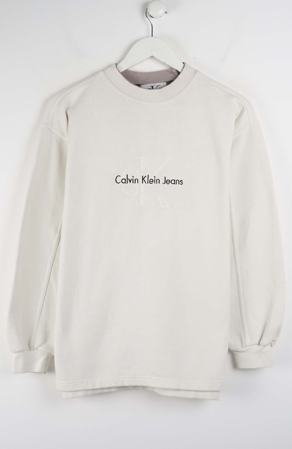 Beige sweatshirt with Calvin Klein Jeans logo on a white hanger