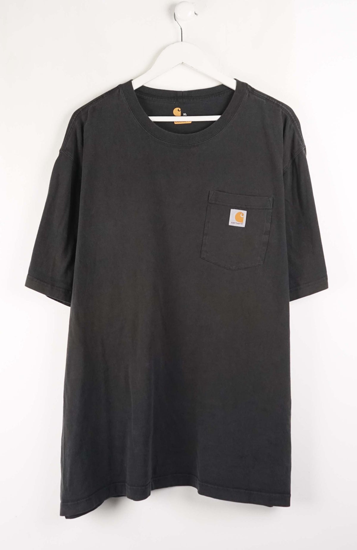 Black t-shirt with a pocket and Carhartt logo on a white background