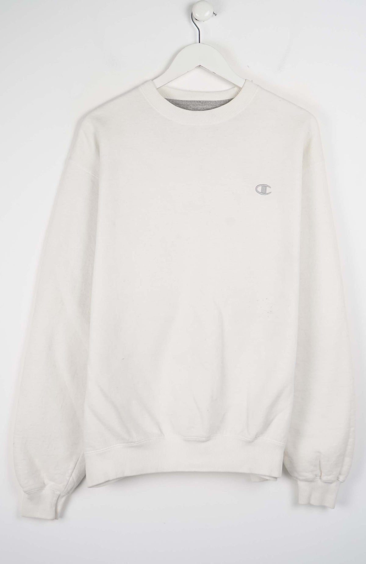 White sweatshirt on a hanger against a white background