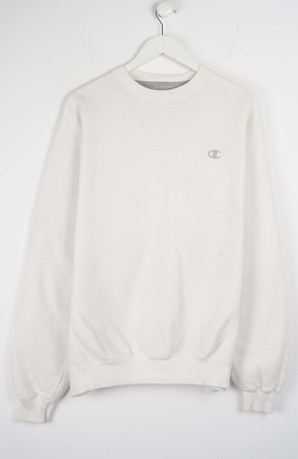 White sweatshirt on a hanger against a white background