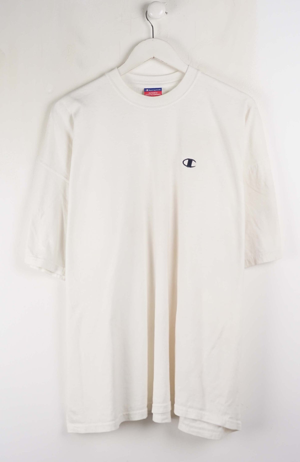 White long-sleeve shirt with a small logo on a hanger against a white background