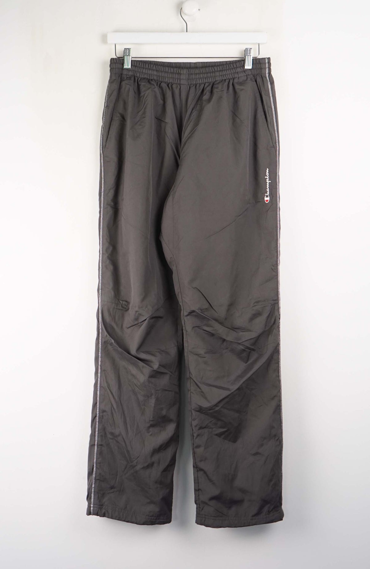 Dark gray pants hanging on a white wall