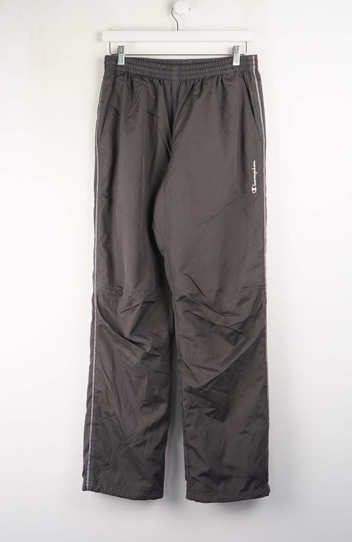 Dark gray pants hanging on a white wall