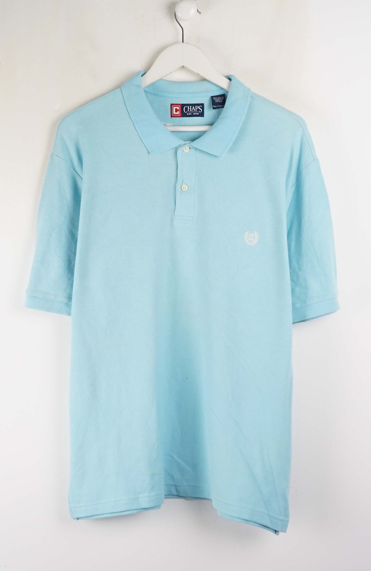Light blue polo shirt on a hanger against a white background