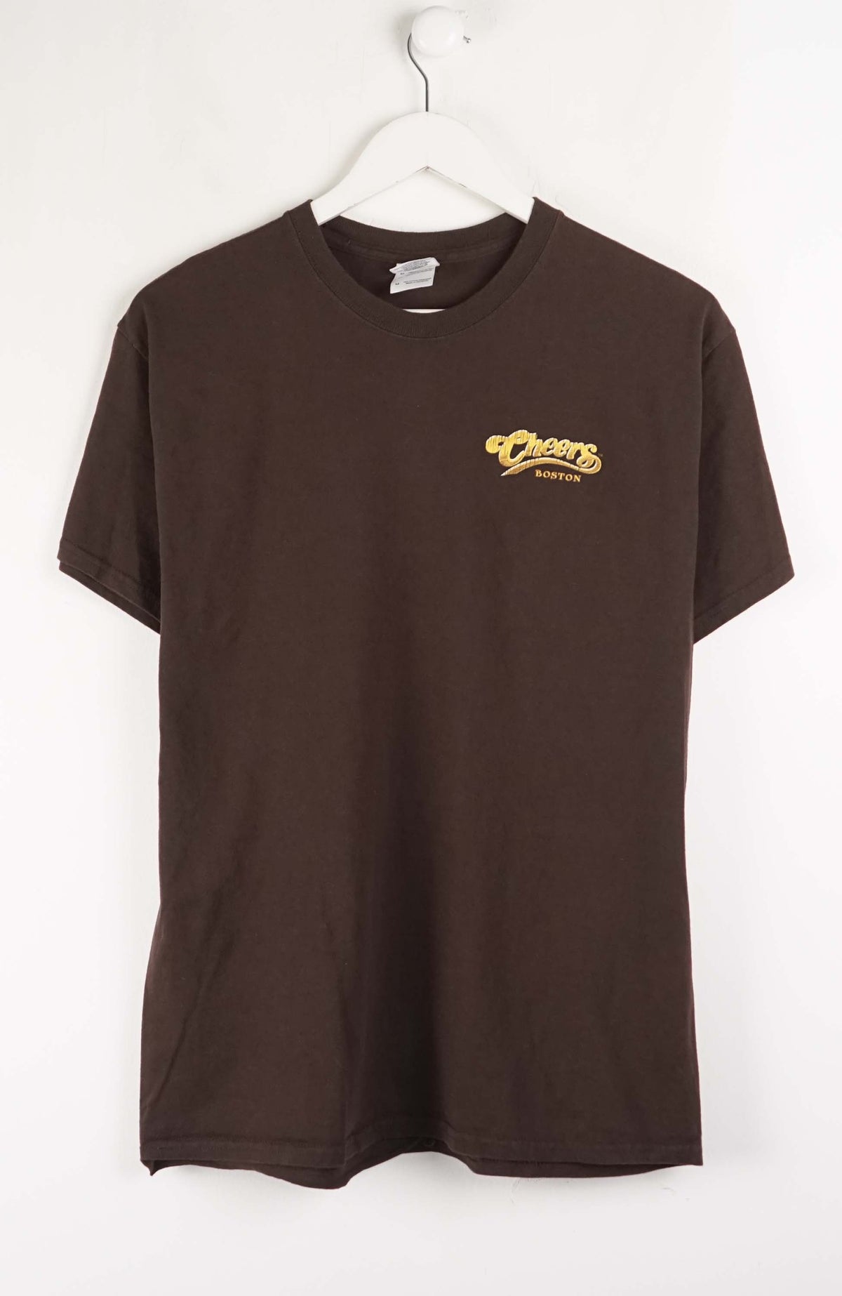 Brown t-shirt with a logo on a white hanger