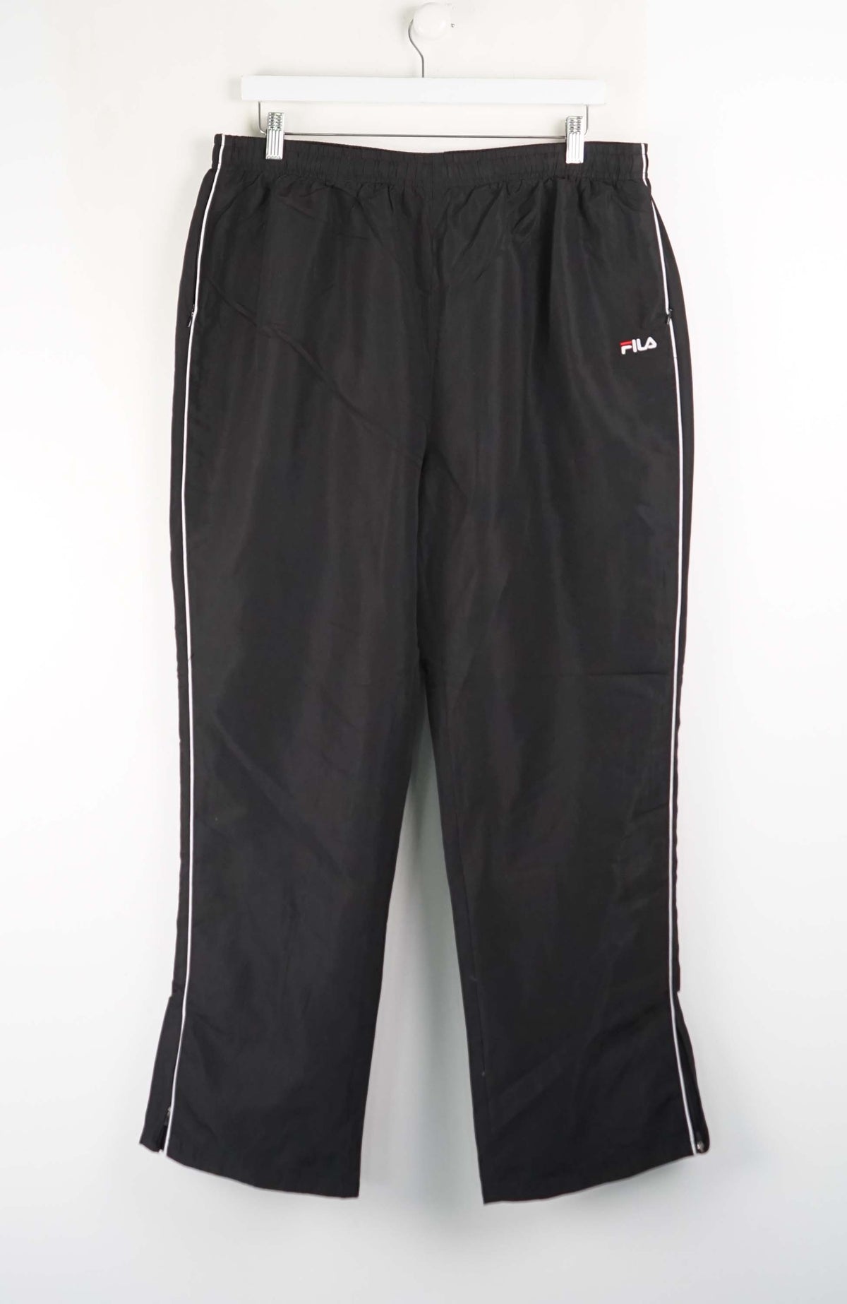Black track pants with white stripes on a white background
