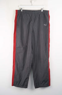 Gray pants with red accents hanging on a white wall