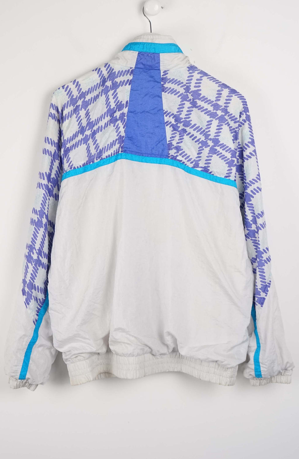 White tracksuit with blue geometric patterns on a white background
