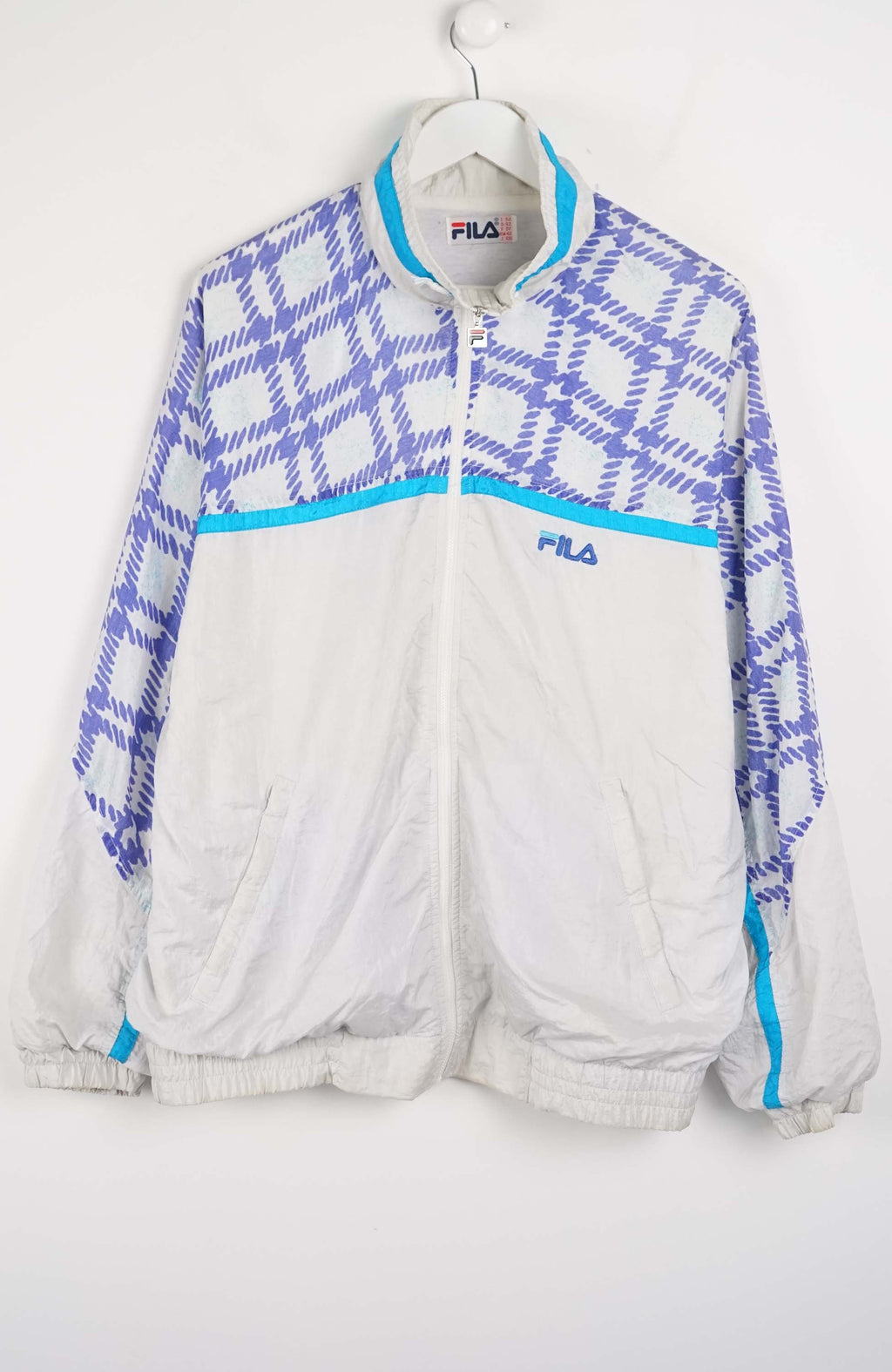 White tracksuit with blue geometric patterns on a white background