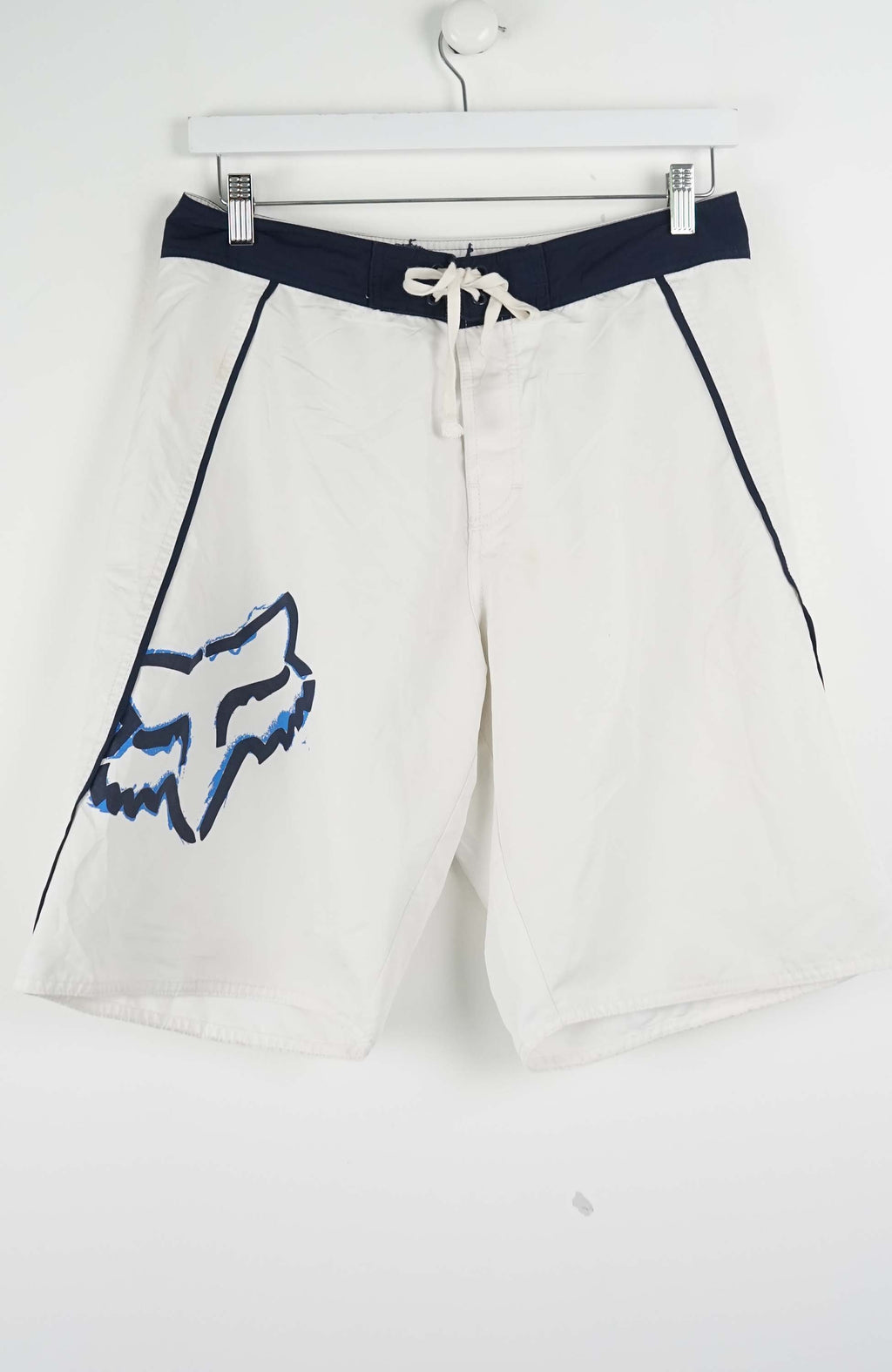 White shorts with a blue logo and black belt on a white background