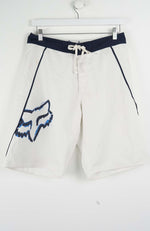 White shorts with a blue logo and black belt on a white background