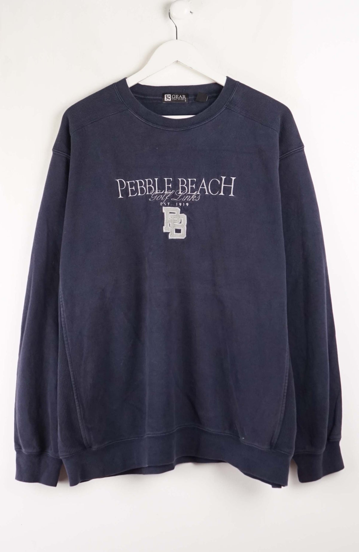 Navy blue sweatshirt with 'Pebble Beach' text on a white background