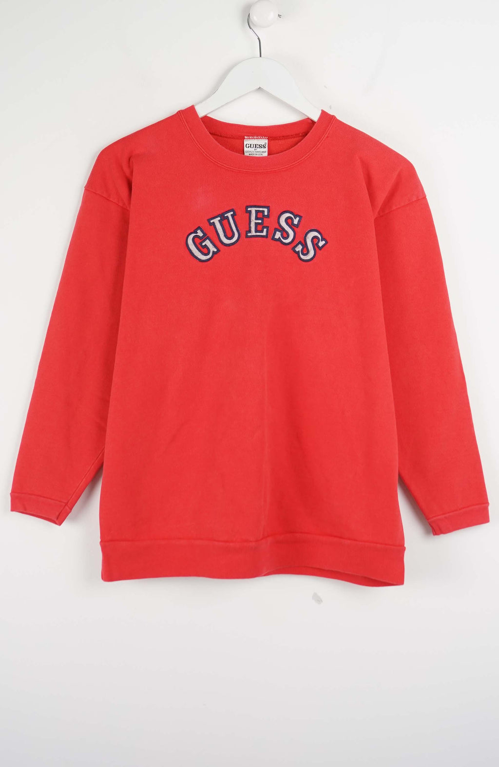 Red sweatshirt with 'Guess' logo on a white background