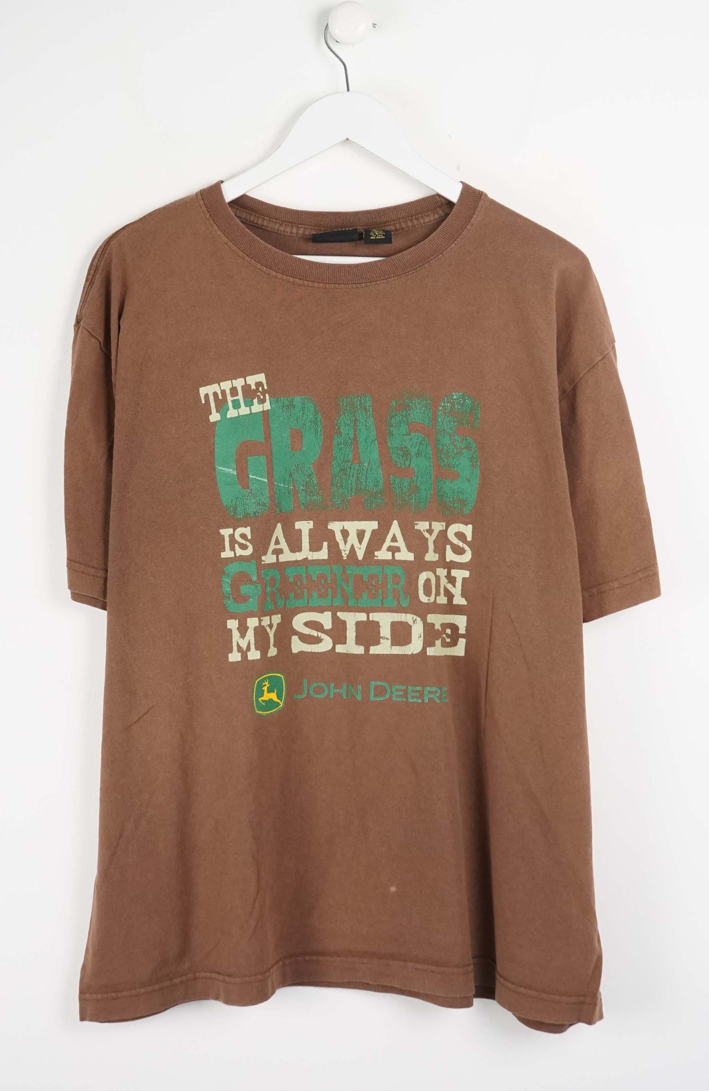 Brown t-shirt with green and white text on a white background