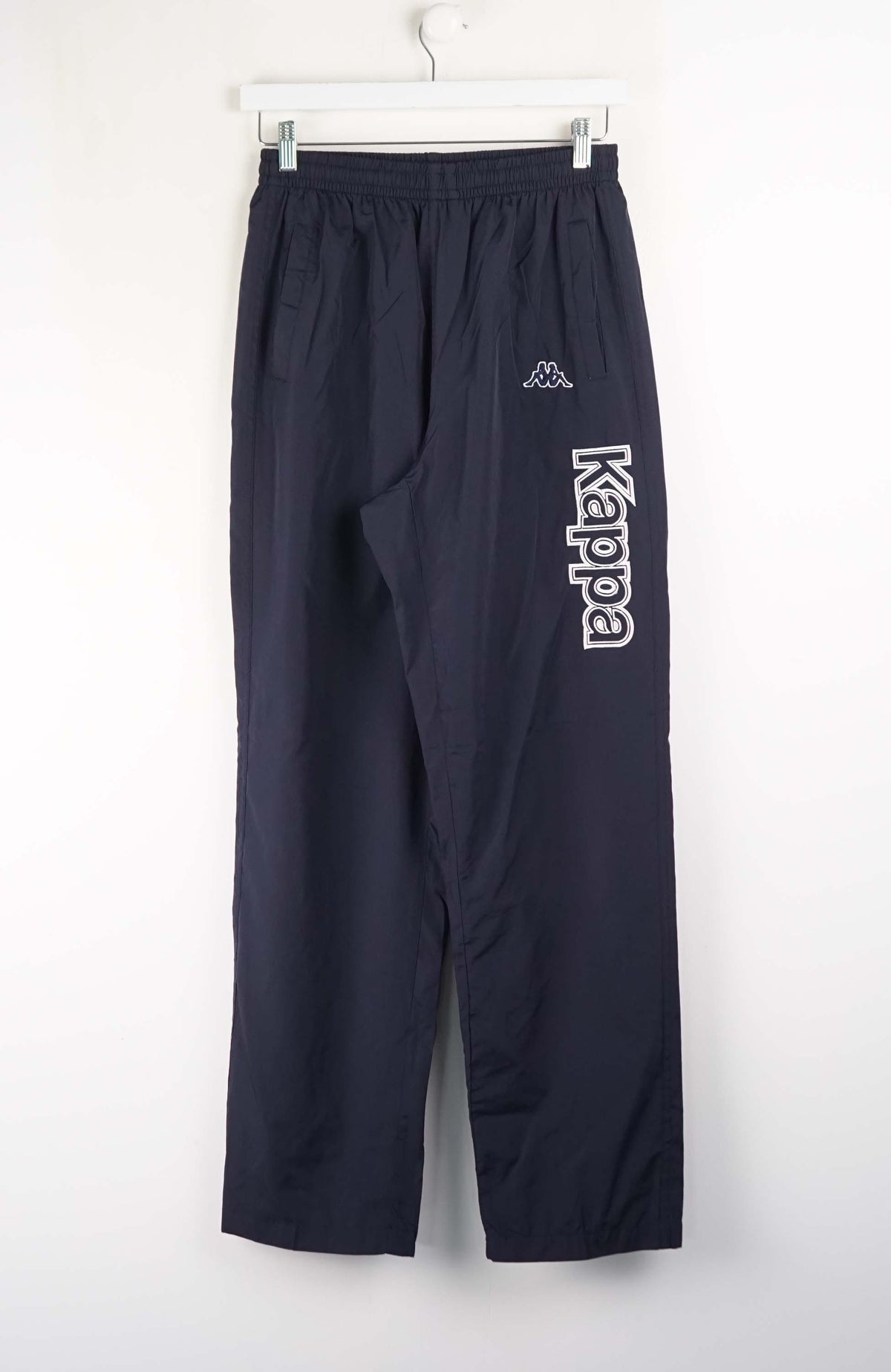 Navy blue pants with 'Kappa' logo on a white background