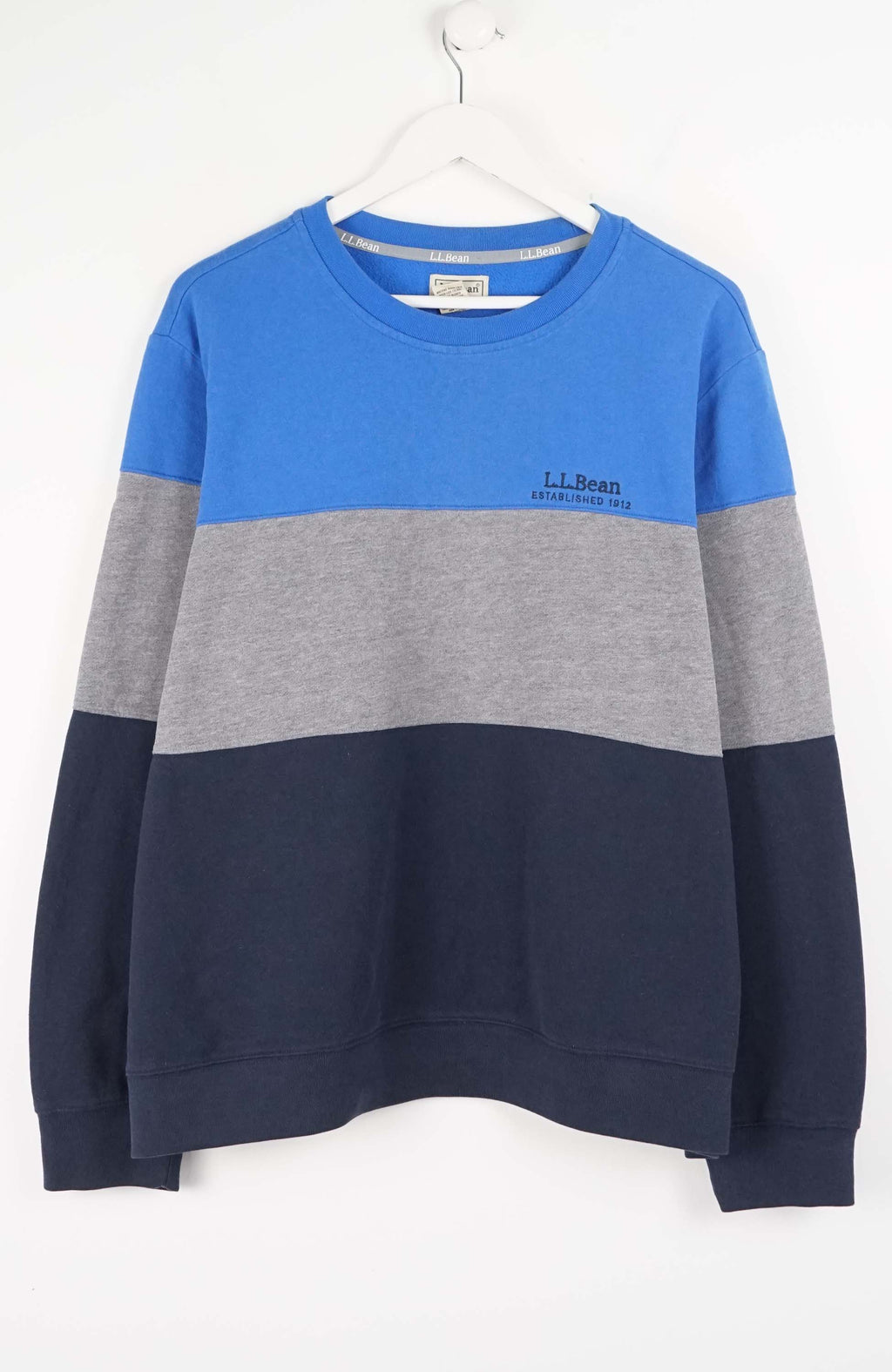 Color-blocked sweater with blue, gray, and navy sections on a white background