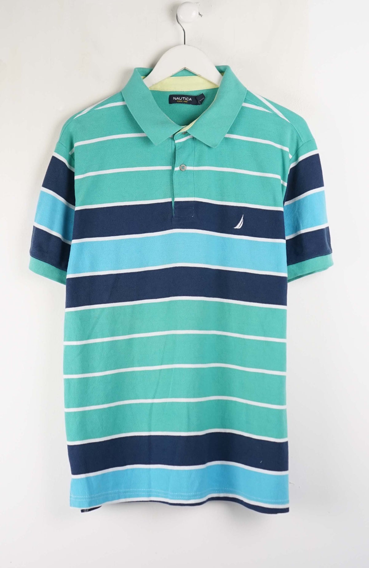 Striped polo shirt with blue and green horizontal stripes on a white hanger