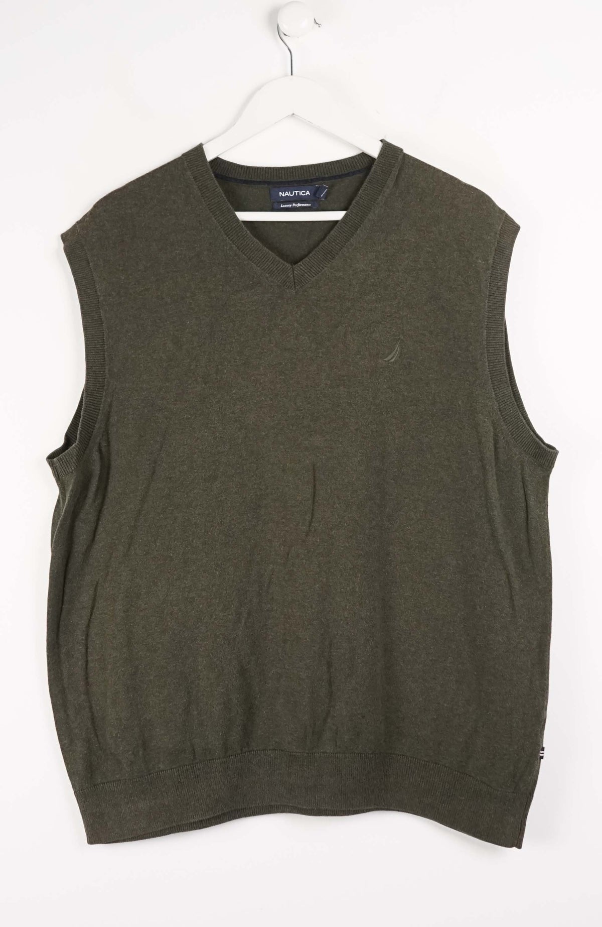 Green sweater vest on a white hanger with a white background