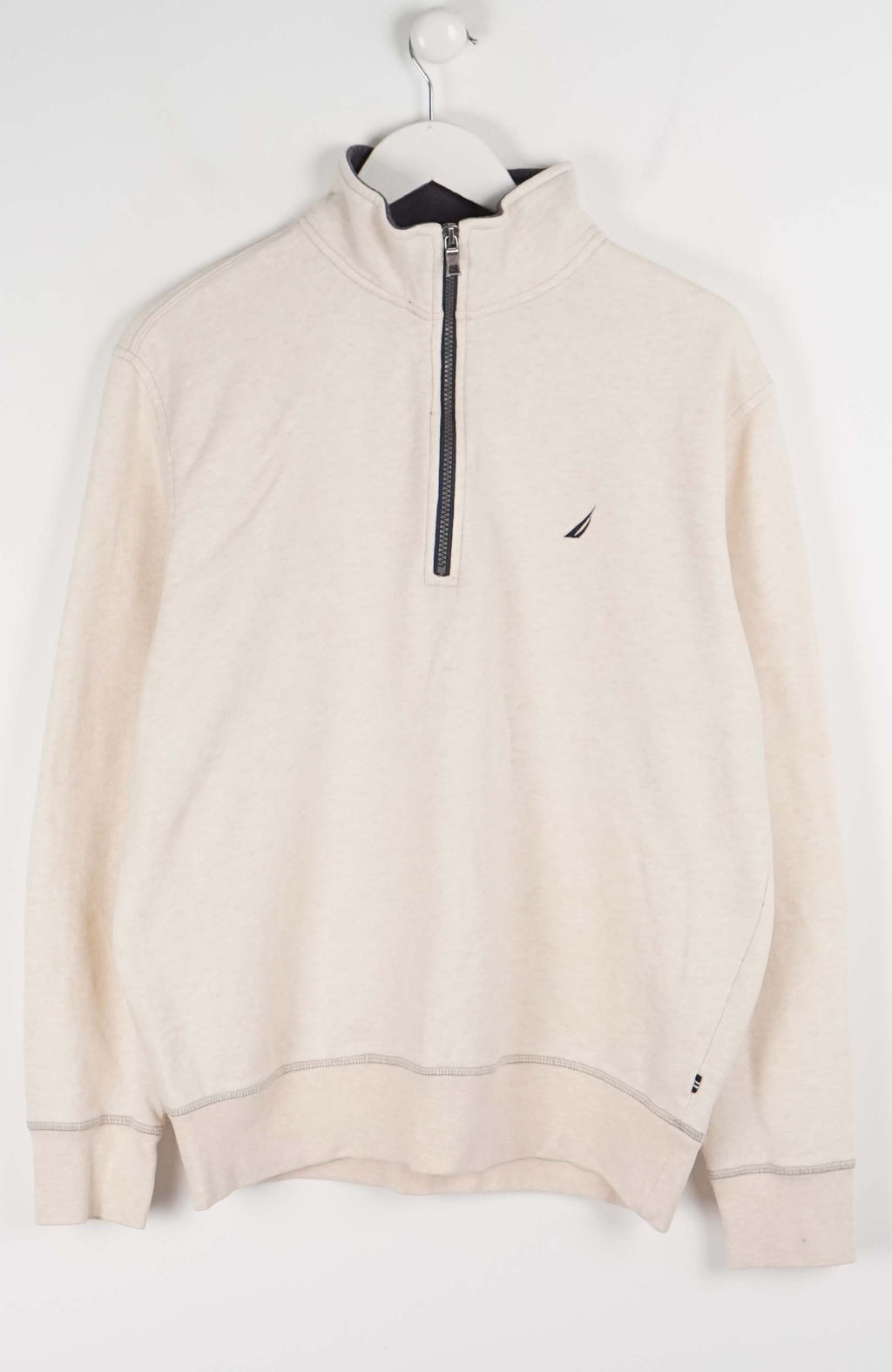 Beige half-zip sweatshirt on a hanger against a white background