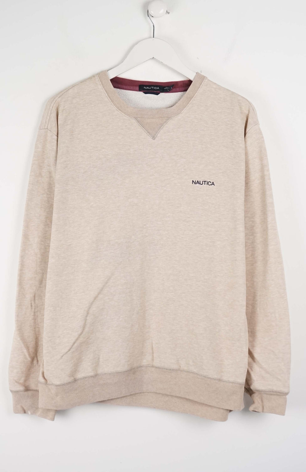 Beige sweatshirt with 'Nautica' logo on a white background