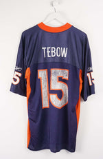 Navy blue sports jersey with orange accents, number 15, and name 'Tebow' on a white background