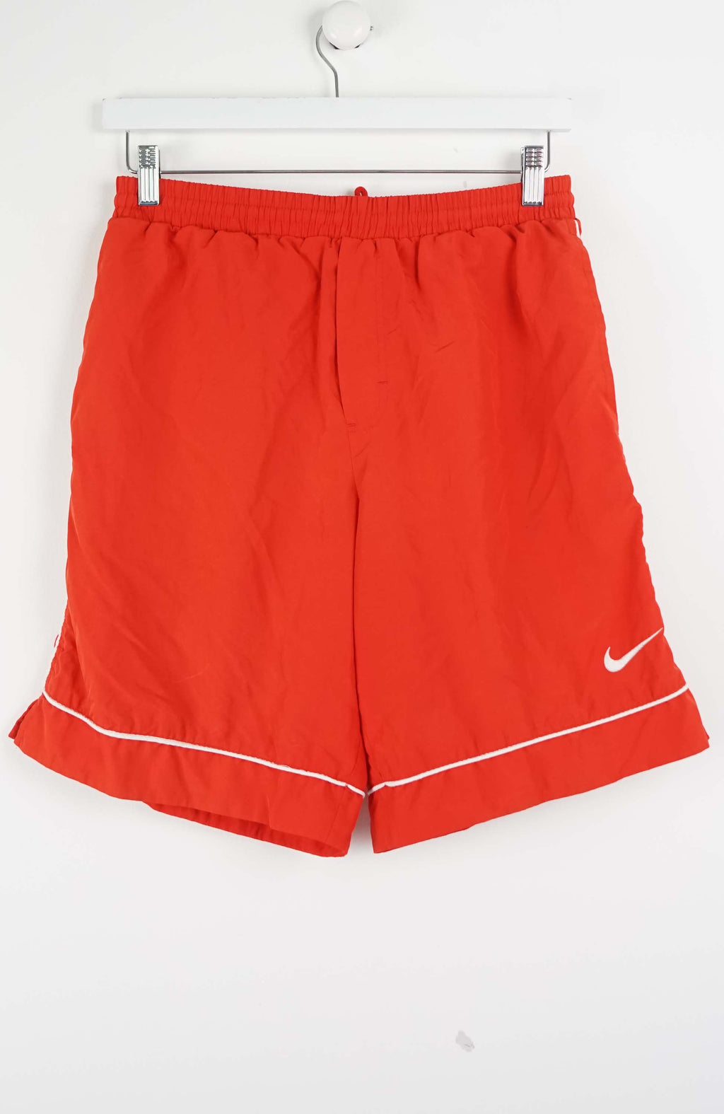 Red shorts with a Nike logo on a white background