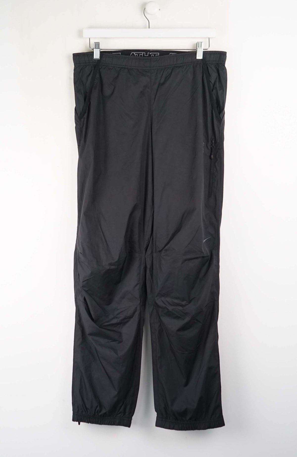 Black pants hanging on a white background