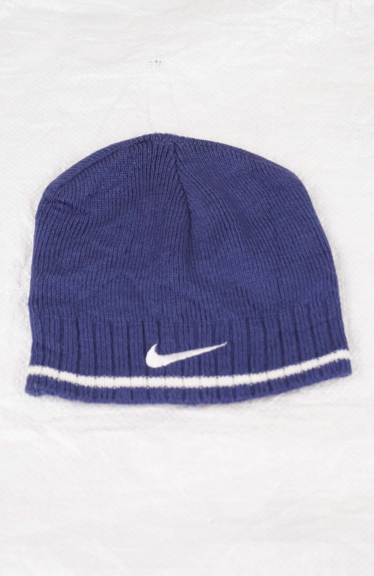 Blue knit beanie with Nike logo on a white background