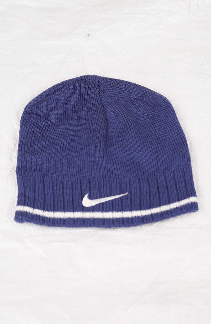 Blue knit beanie with Nike logo on a white background
