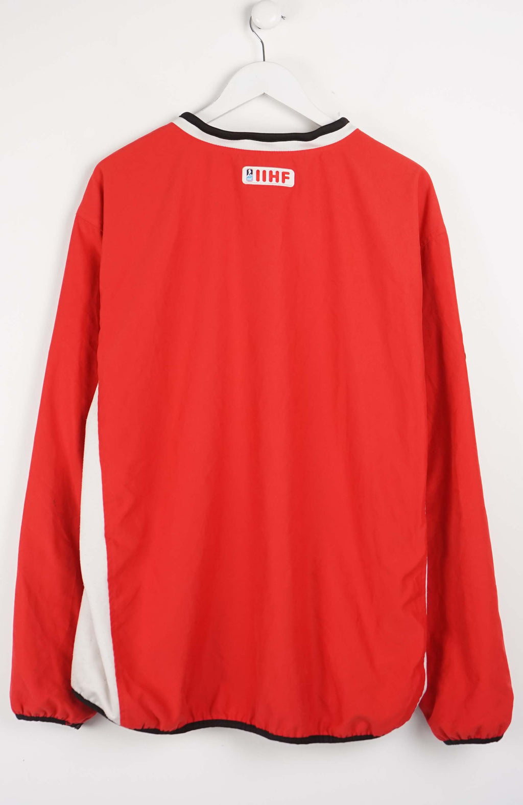 Red sports jersey with Canadian flag logos on a white background