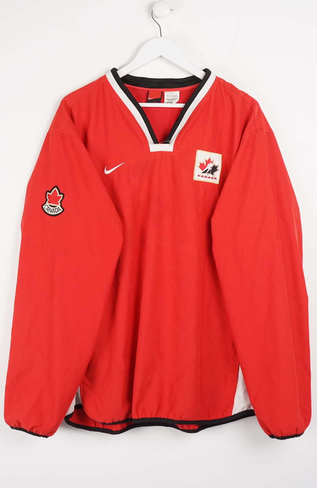 Red sports jersey with Canadian flag logos on a white background