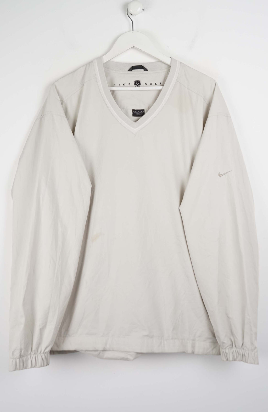 Beige sweater on a hanger against a white background