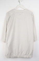 Beige dress on a hanger against a white background