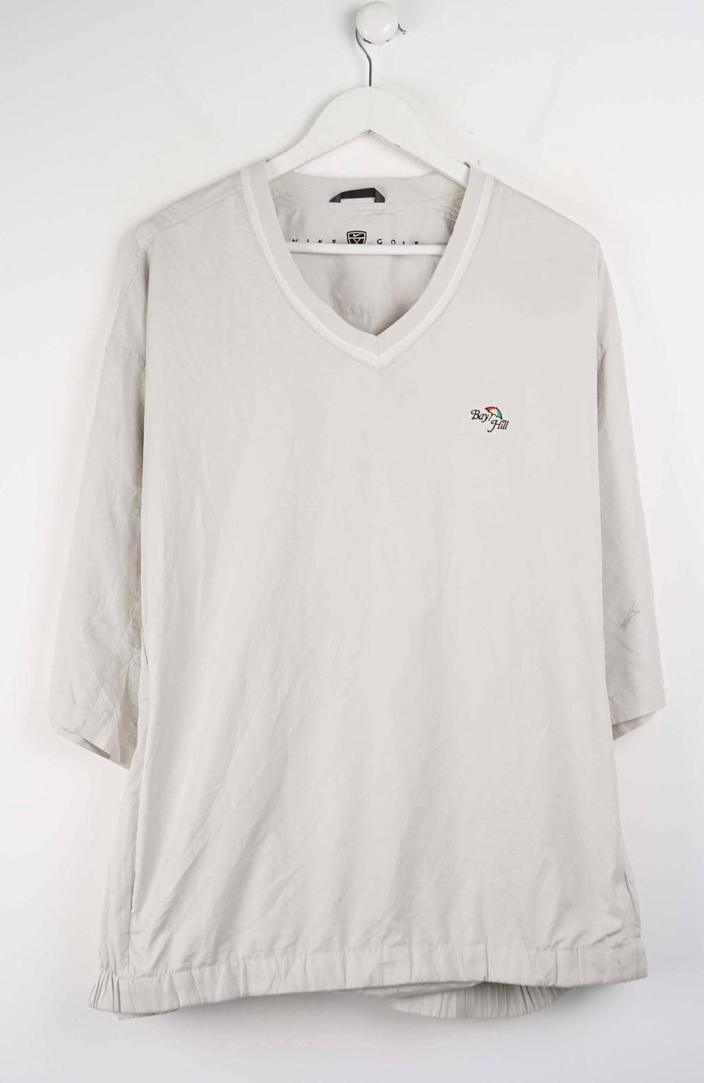 Beige V-neck shirt with a small logo on a white background