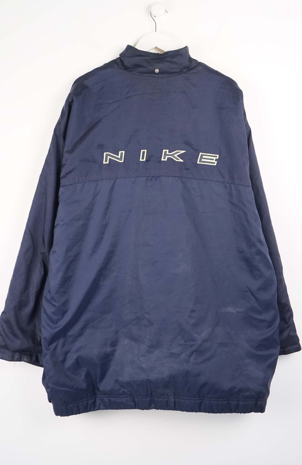 Navy blue jacket on a hanger against a white background