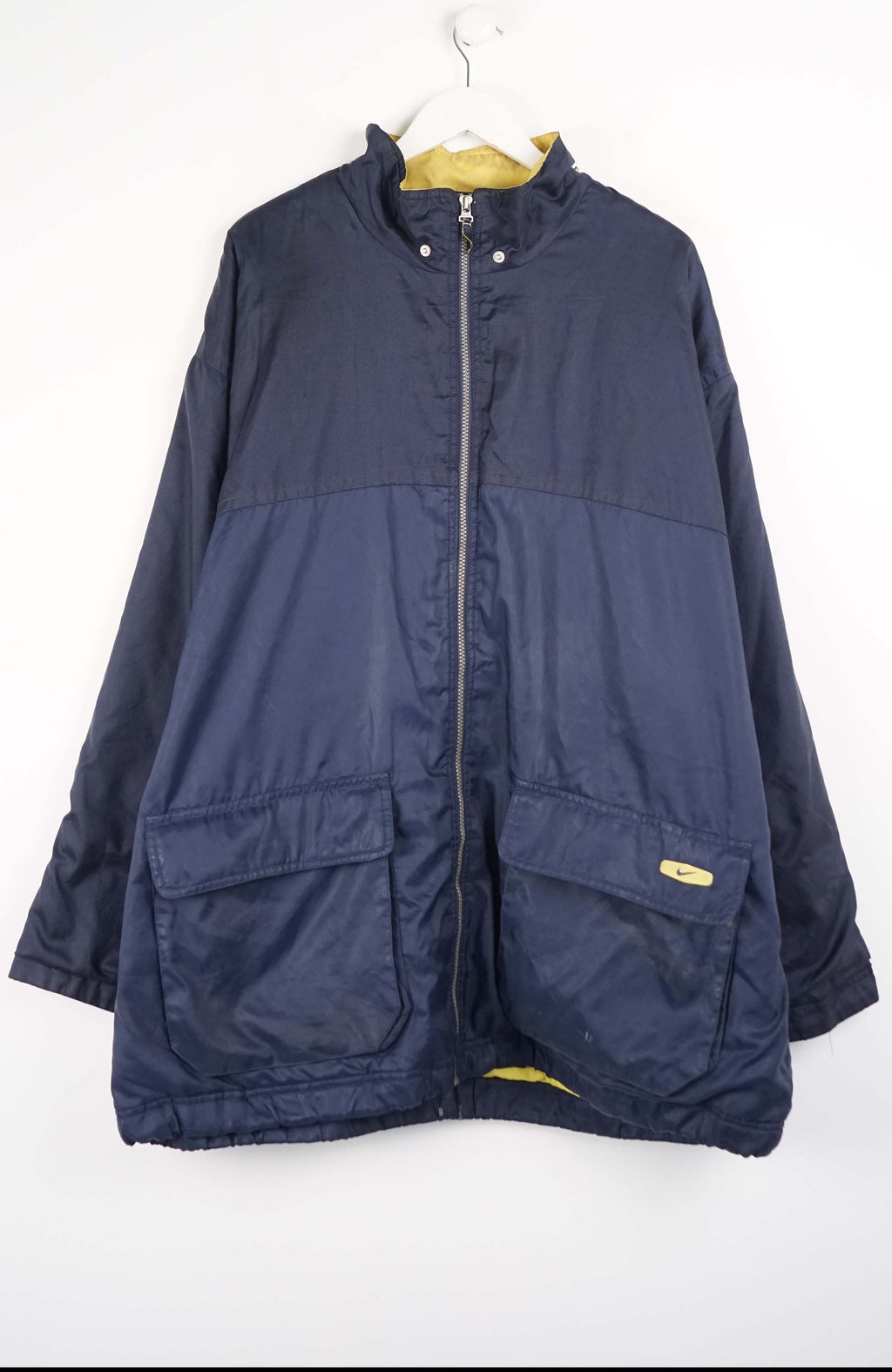 Navy blue jacket on a hanger against a white background