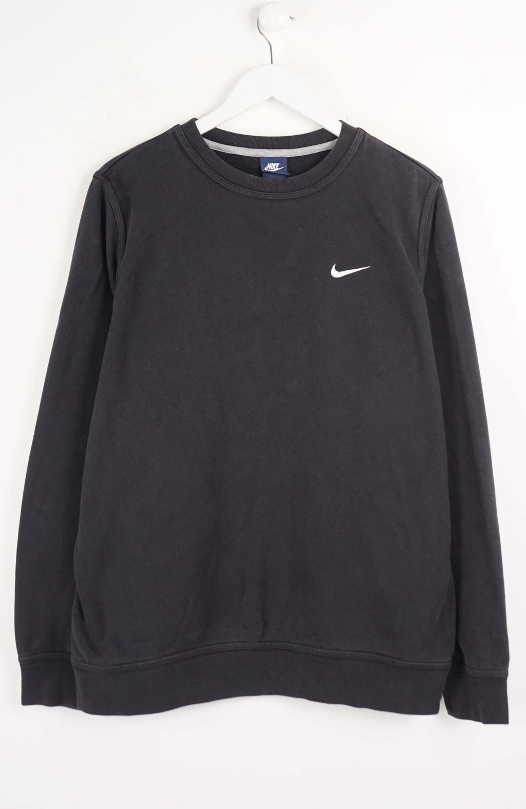 Black Nike sweatshirt on a white hanger against a white background