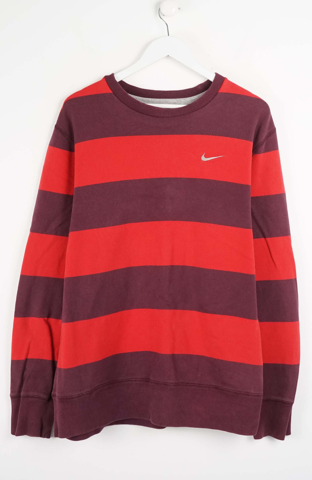 Red and purple striped sweatshirt with Nike logo on a white background