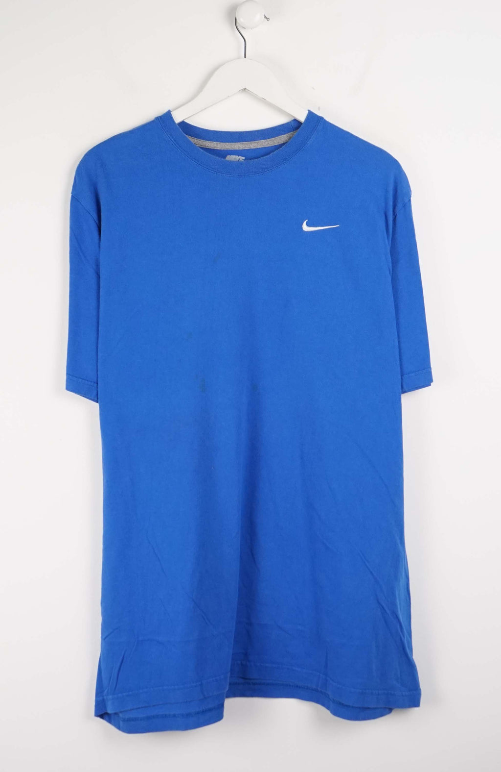 Blue Nike t-shirt on a white hanger against a white background