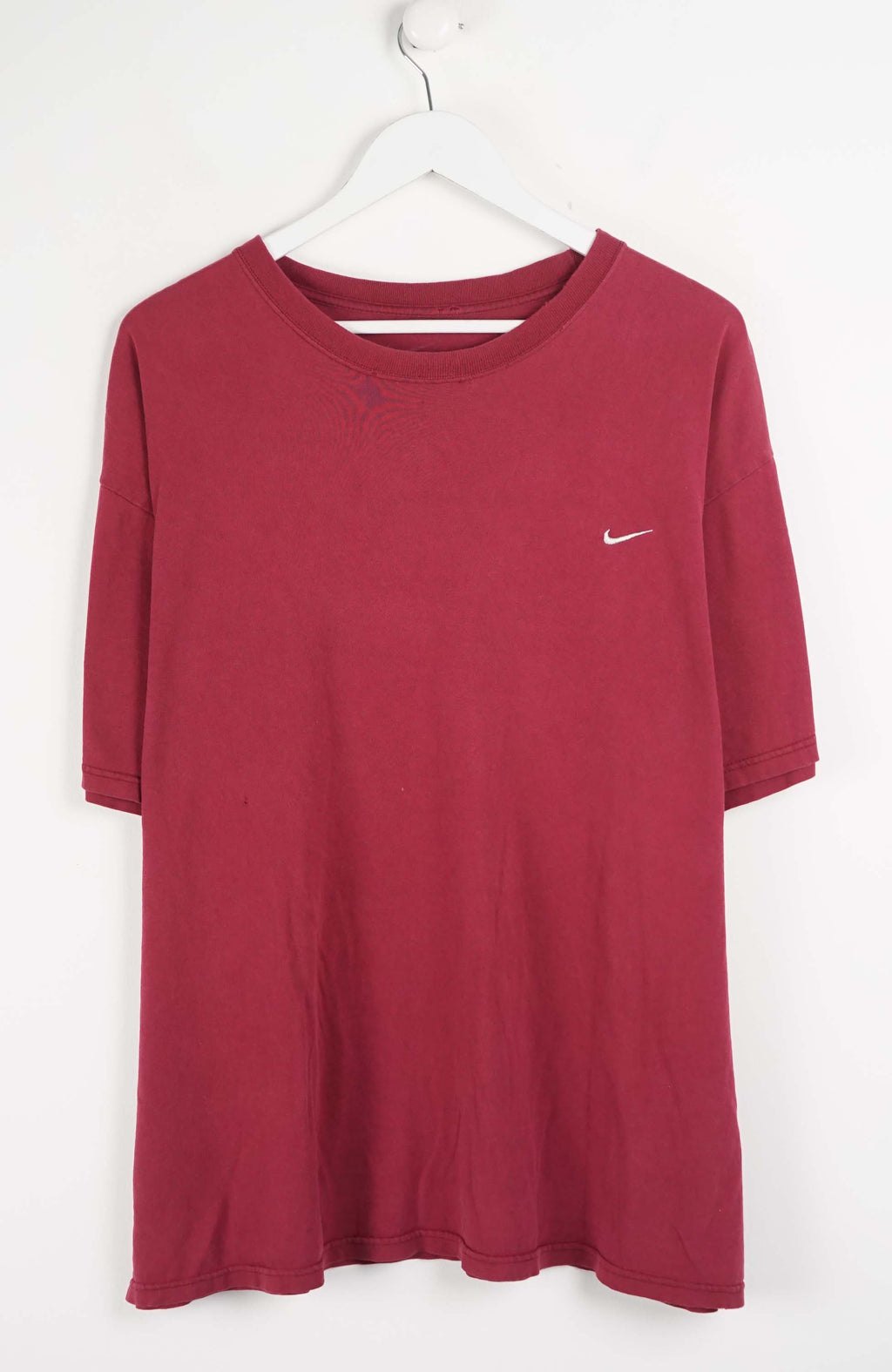 Red t-shirt with a Nike logo on a white hanger