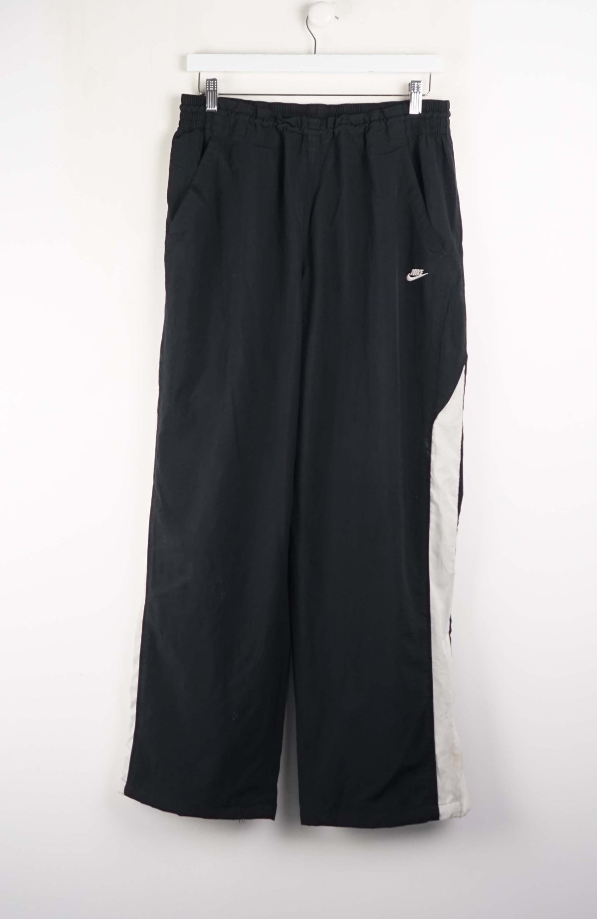 Black wide-leg pants with white side stripe on a white background