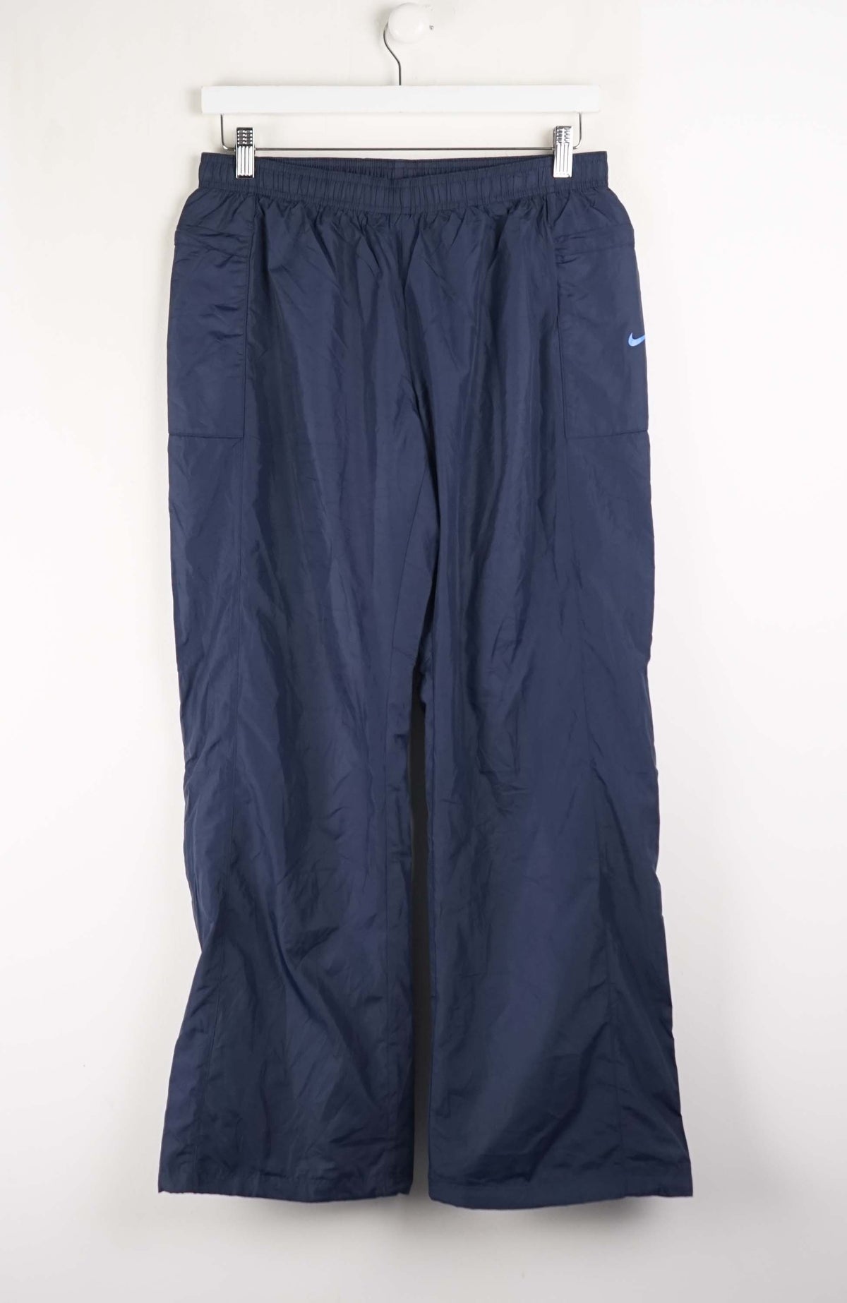 Navy blue pants with a Nike logo on a white background