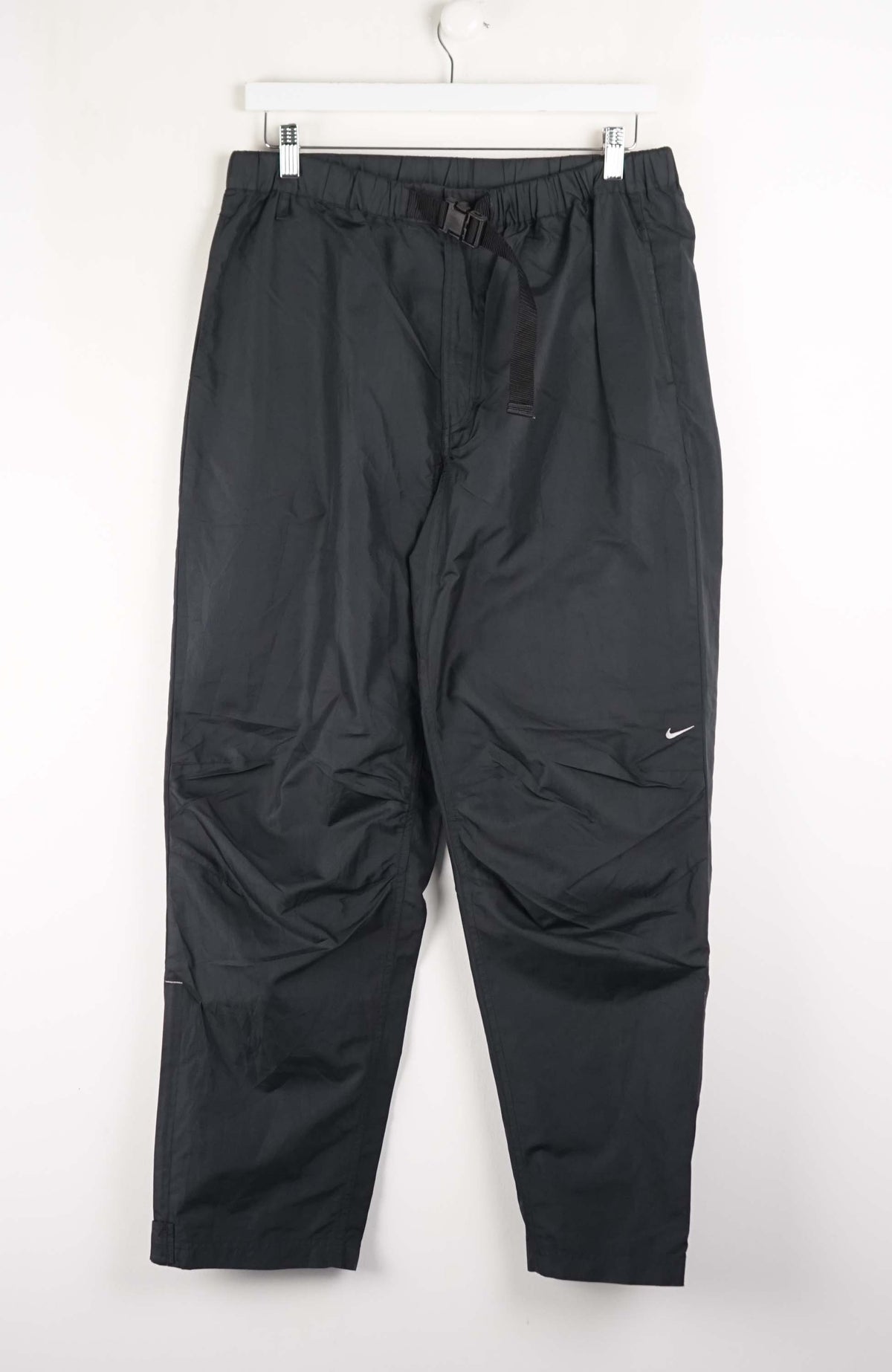 Black pants with a Nike logo on a white background