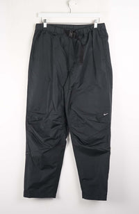 Black pants with a Nike logo on a white background