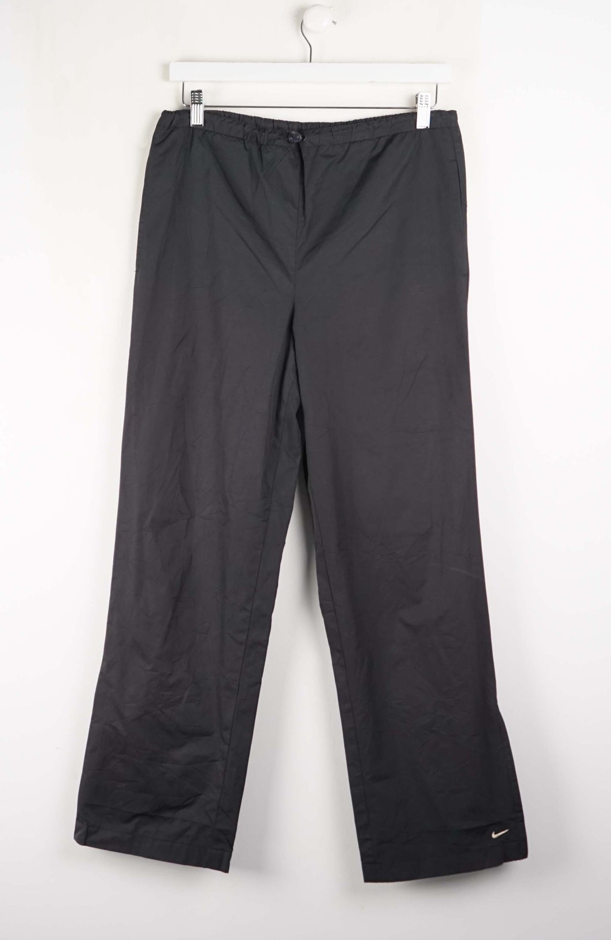 Black pants with a Nike logo on a white background