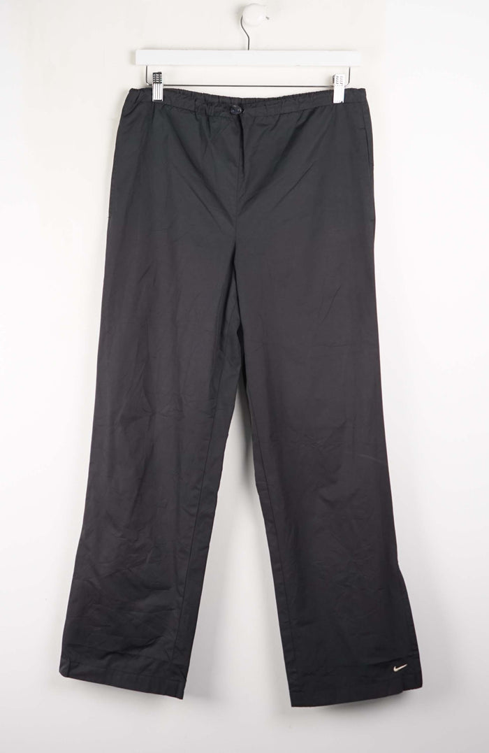 Black pants with a Nike logo on a white background