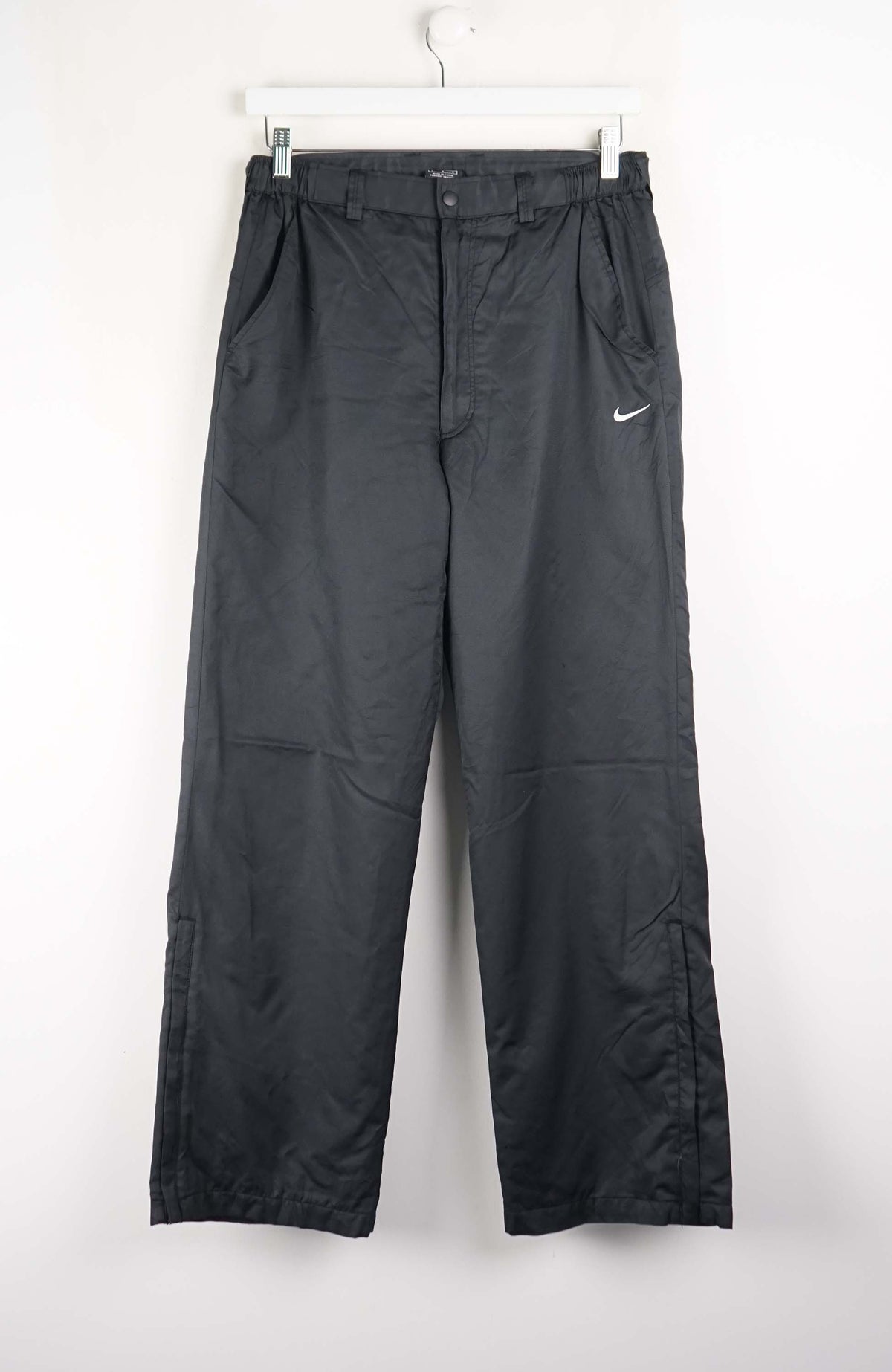 Black pants with a Nike logo on a white background