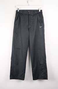 Black pants with a Nike logo on a white background