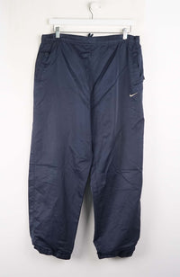 Navy blue pants with a Nike logo on a white hanger