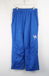 Blue athletic pants with a logo on a white background